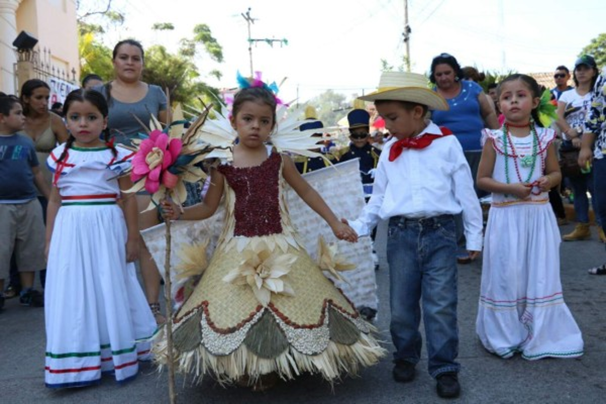 Dos niños se toman de la mano en el desfile realizado en el occidente de Honduras.