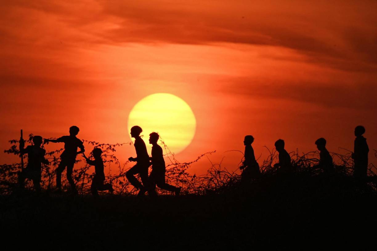 <b>Pakistán</b>Se recortan las siluetas de los niños mientras juegan contra el telón de fondo de la última puesta de sol de 2022, en Lahore el 31 de diciembre de 2022. 