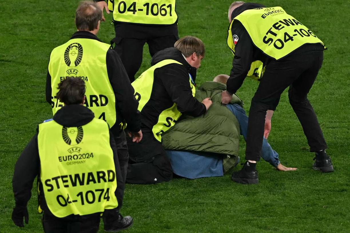 Miembros de seguridad detuvieron al aficionado de Albania que invadió el campo.