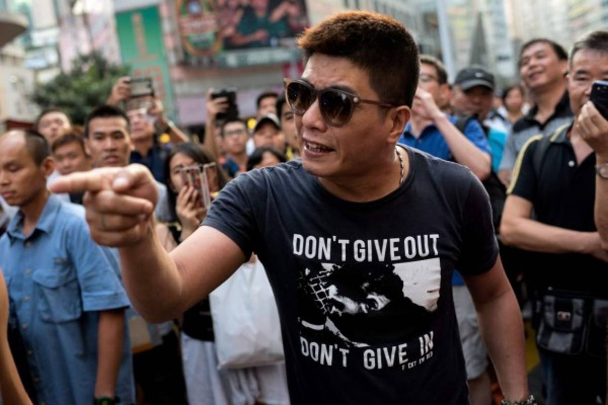 Un grupo de hombres derribaron una barricada en una protesta pro-democracia en el distrito de Causeway Bay de Hong Kong el 3 de octubre de 2014. AFP