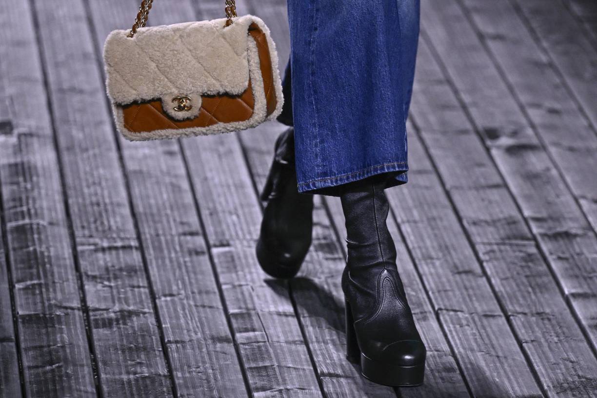 En accesorios incluye botas con plataformas y sus clásicos bolsos midi.