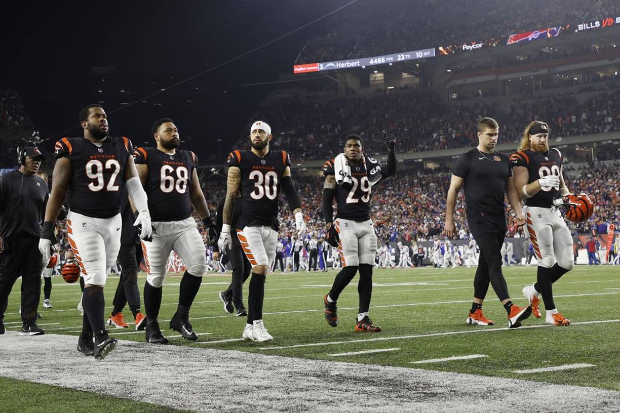 Los jugadores de los Cincinnati Bengals abandonan el campo después de la suspensión del partido.