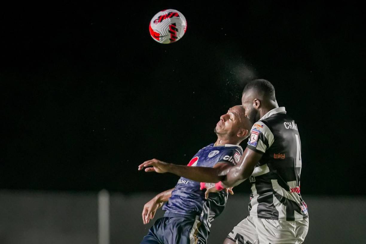 Gustavo Chará, del Tauro FC, y Eddie Hernández, de Motagua, saltando por el balón.