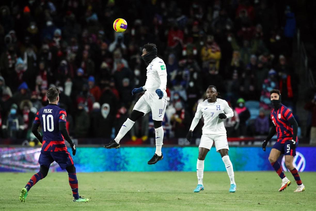 Bryan Róchez saltando para cabecear el balón ante la mirada de Pulisic y Alberth Elis.
