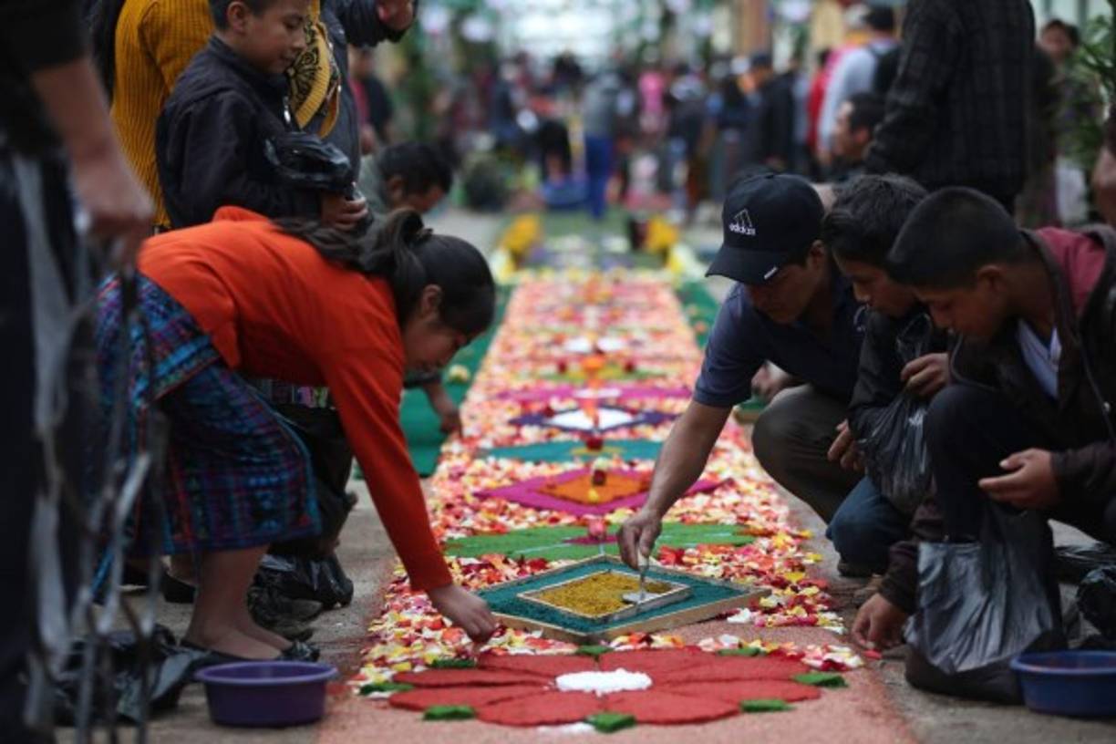 Apenas cuando han salido los primeros rayos de sol, los vecinos empiezan a elaborar alfombras de colores de más de tres kilómetros que luego recorrerá el cortejo de la imagen del Santísimo para llevar bendiciones a este pequeña localidad maya kaqchikel, con la marimba sonando de fondo.<br/>