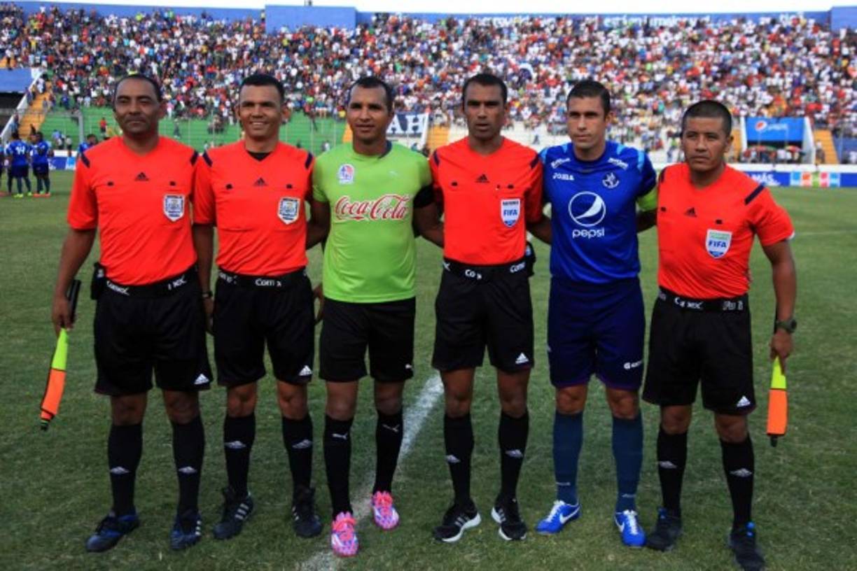 Los capitanes de Olimpia, Donis Escober, y Motagua, Júnior Izaguirre, posando junto a la cuarteta arbitral en los actos protocolares.