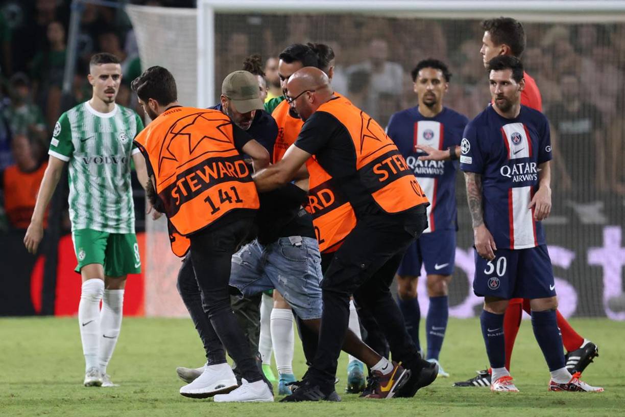 Más miembros de seguridad entraron al campo para detener al aficionado, mientras Messi observaba.