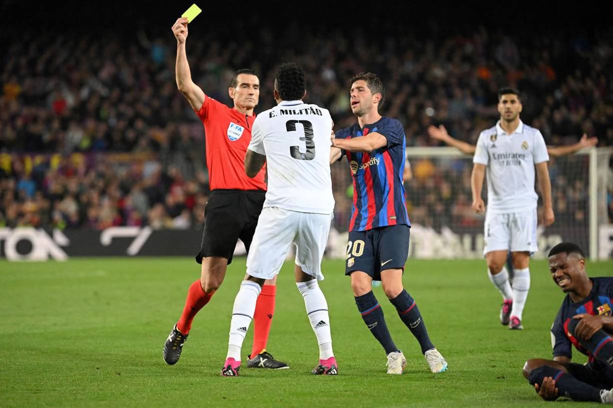 El árbitro Juan Martínez Munuera le muestra tarjeta amarilla a Éder Militao tras una falta a Ansu Fati.