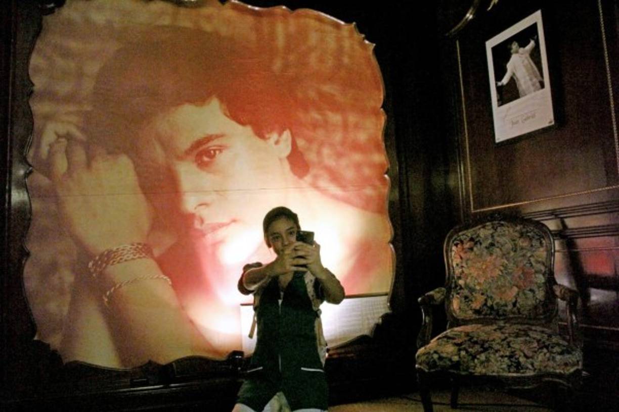 Una fan se toma una selfie delante de la imagen del 'Divo de Juárez'.