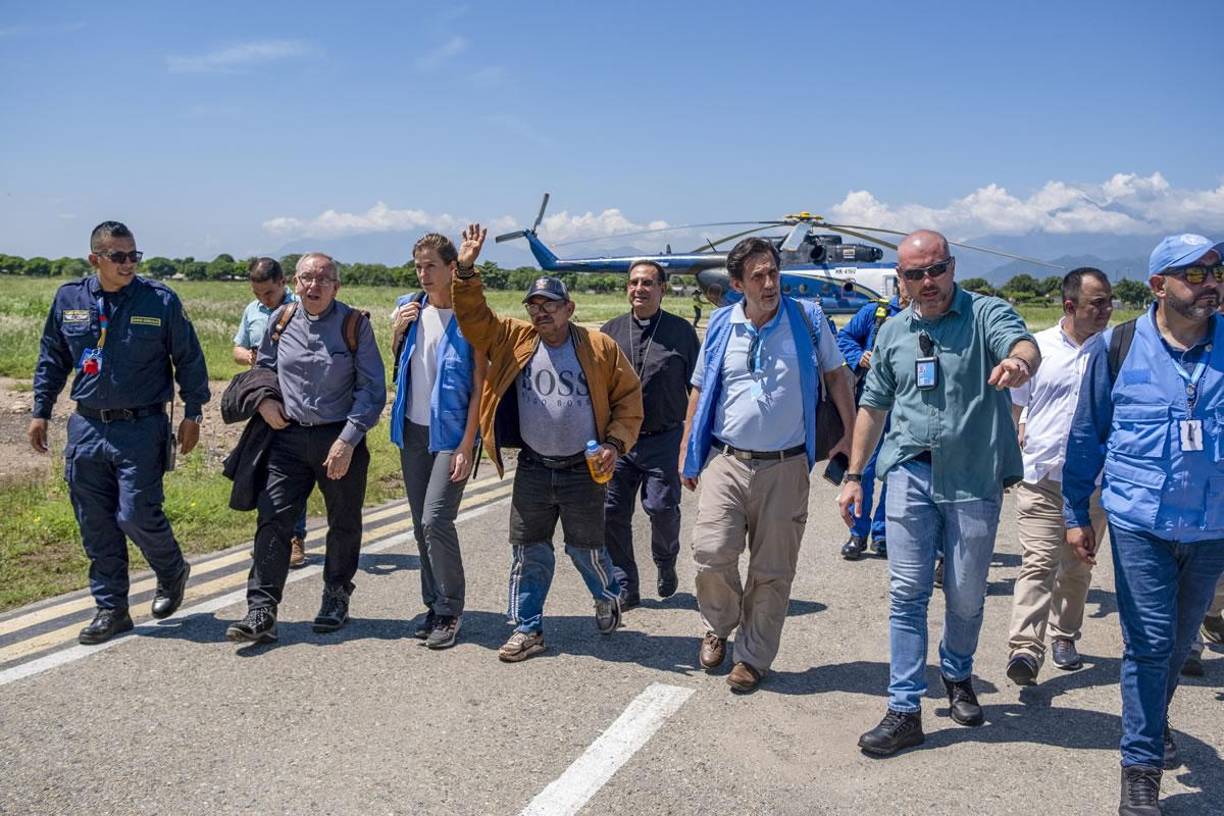 Representantes de Naciones Unidas, la Defensoría del Pueblo, la Iglesia católica y policías lo acompañaron en la pista de aterrizaje mientras saludaba con la mano en alto y caminaba a paso lento. 