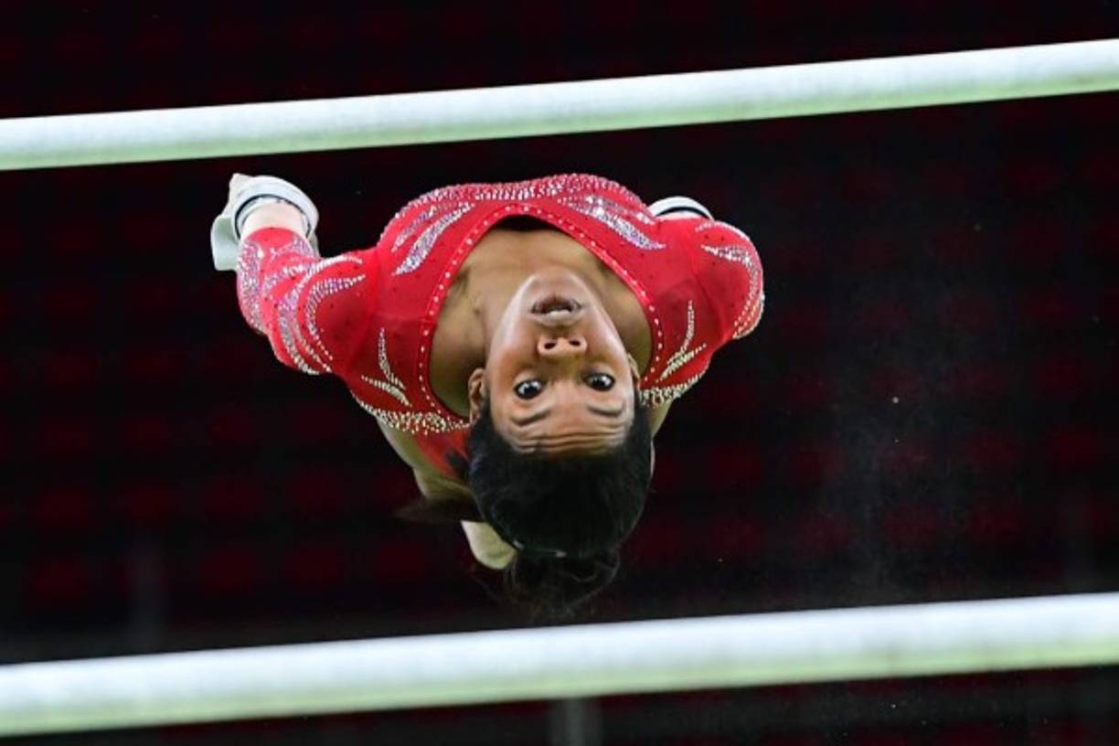 GIMNASIA. Espectacular. La gimnasta estadounidense Gabrielle Douglas muestra sus habilidades en las barras asimétricas de la gimnasia artística de mujeres.