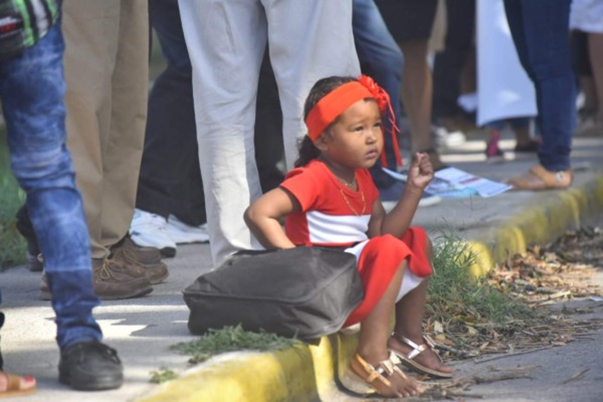 Esta pequeñita llegó para acompañar a sus padres, cansada y asombrada al ver tanta gente se sentó en el bordillo de la calle.