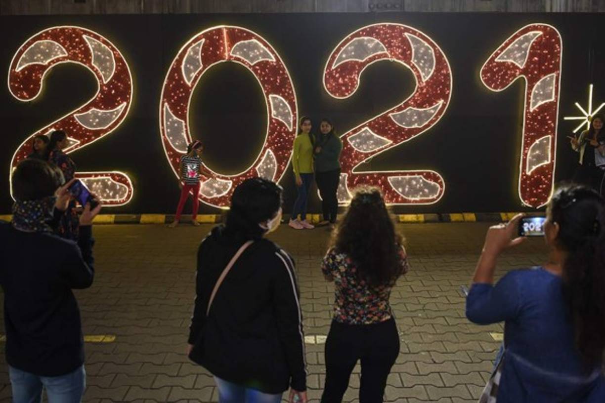 INDIA. La gente posa cerca de una decoración en la víspera de Año Nuevo en un centro comercial en Mumbai el 31 de diciembre de 2020. (Photo by Punit PARANJPE / AFP)