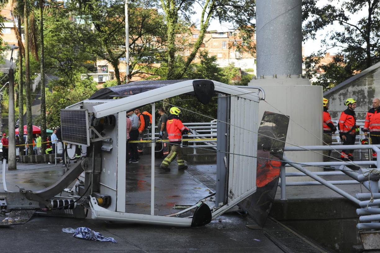 Firefighters work at the site where a Metrocable cable railway cabin fell after derailing at one of the stations in Medellin, Colombia, on June 26, 2024. (Photo by JAIME SALDARRIAGA / AFP)
