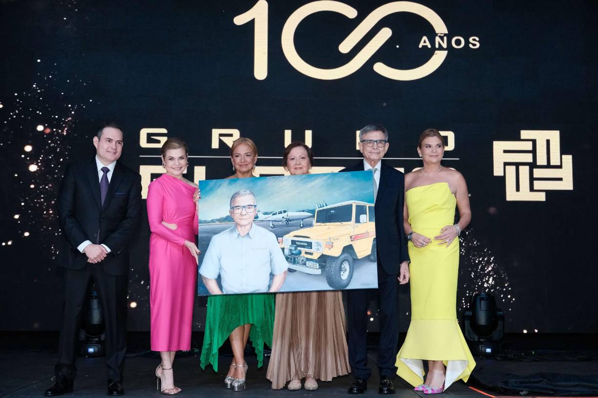 Grupo Flores realizó un magno evento, en el cual festejó 100 años de servir al pueblo hondureño. La celebración tuvo lugar en el Centro de Convenciones del Hotel Copantl, lugar que se escogió para rendir homenaje a la trayectoria que esta empresa hondureña ha logrado gracias a clientes, colaboradores, socios estratégicos y la familia Flores. El evento estuvo cargado de emociones positivas, se entregaron reconocimientos a Alan E. Flores, actual presidente de la compañía. Además, se contó con la presencia de Masahiro Inoue, CEO de Toyota para América Latina y el Caribe. En la postal, los hijos de Alan E. Flores le hacen entrega de un cuadro significativo a su querido padre, guía y soporte de su camino en esta vida. 