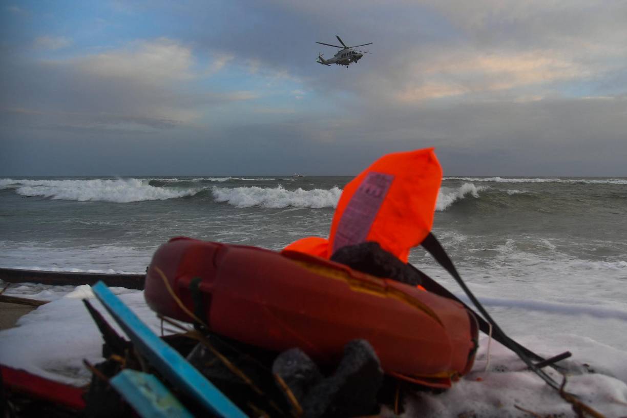 A helicopter of the Italian law enforcement agency 'Guardia di Finanza' flies on February 26, 2023 over the beach of Steccato di Cutro, south of Crotone, where debris of a shipwreck were washed ashore after a migrants' boat sank off Italy's southern Calabria region. - 59 migrants, including a tiny baby, died after their overloaded boat sank early on February 26, 2023 in stormy seas off Italy's southern Calabria region, Italian media and rescue services reported. (Photo by Alessandro SERRANO / AFP)
