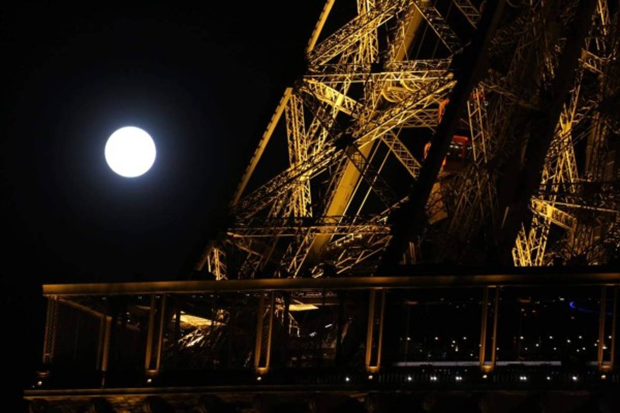 La luna aparece detrás de la Torre Eiffel en París. Los observadores disfrutarán el doble espectáculo de una luna más grande de lo normal y además eclipsada.