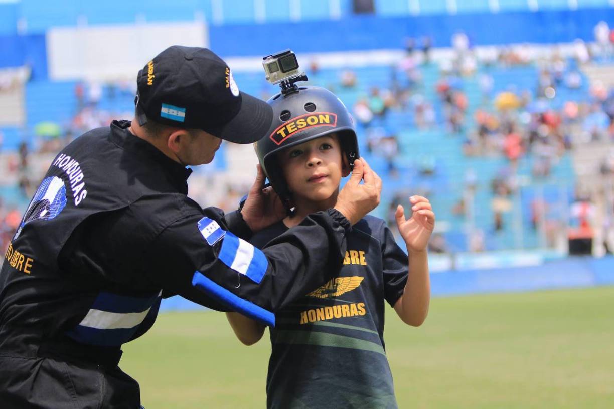 Paracaidista coloca un casco a su hijo para goce de la alegría y la emoción de ser un teniente de la Fuerza Aérea.