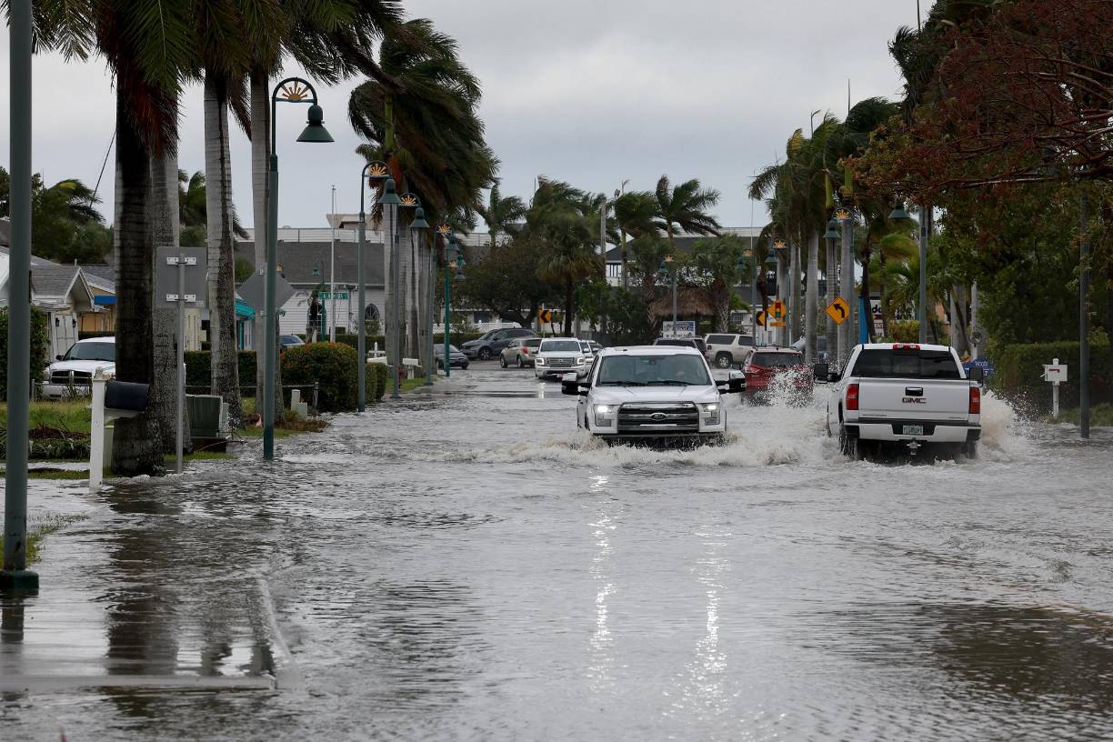 FORT PIERCE, FLORIDA - NOVEMBER 10: Vehicles drive through a flooded street after Hurricane Nicole came ashore on November 10, 2022 in Fort Pierce, Florida. Nicole came ashore as a Category 1 hurricane before hitting Florida’s east coast. Joe Raedle/Getty Images/AFP (Photo by JOE RAEDLE / GETTY IMAGES NORTH AMERICA / Getty Images via AFP)