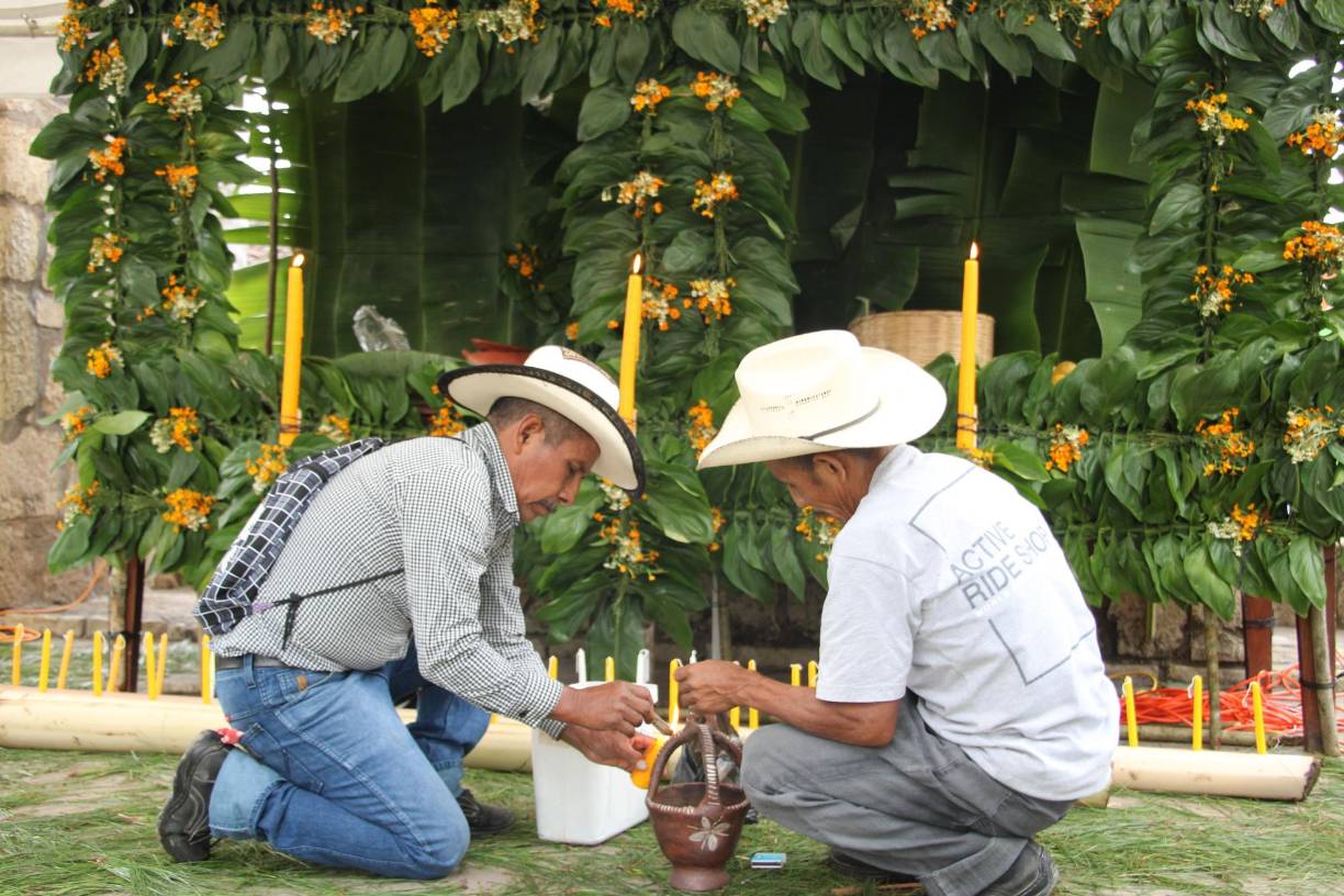 La plaza central de Copán Ruinas se vistió de fiesta y el altar de la bonanza fue uno de los principales atractivos. Dos miembros del Pueblo Maya Chortí encienden velas para el ritual.