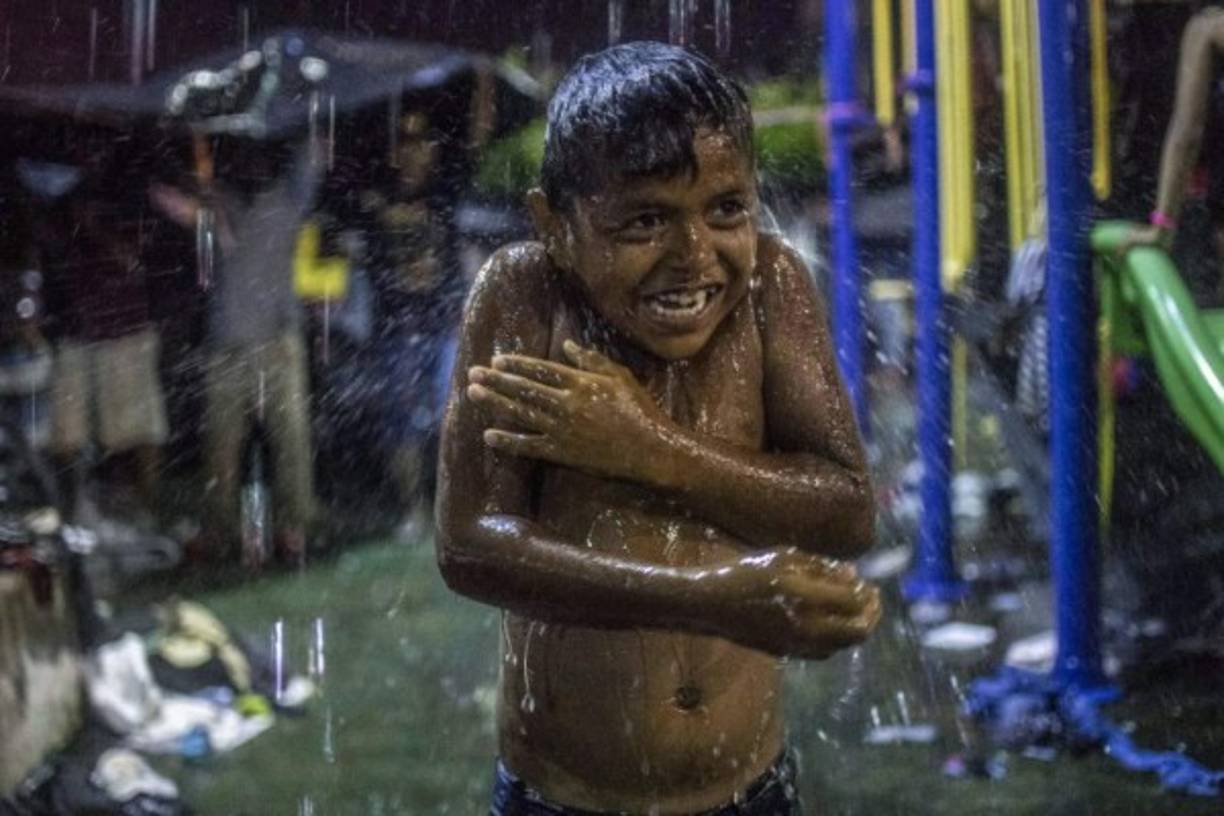 Un niño miembro de la caravana se baña en Mapastepec, estado de Chiapas, México.