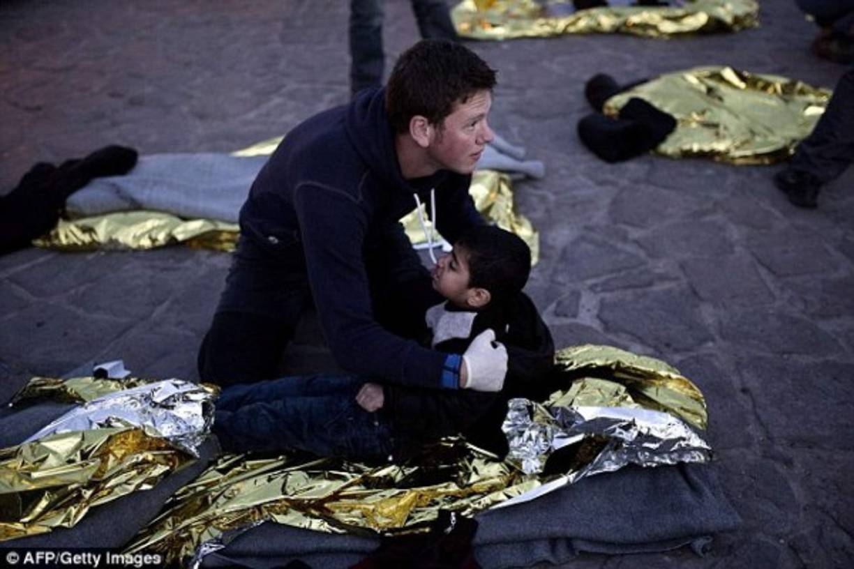 Un paramédico sostiene a uno de los menores mientras espera por una ambulancia para trasladarlo a un hospital.