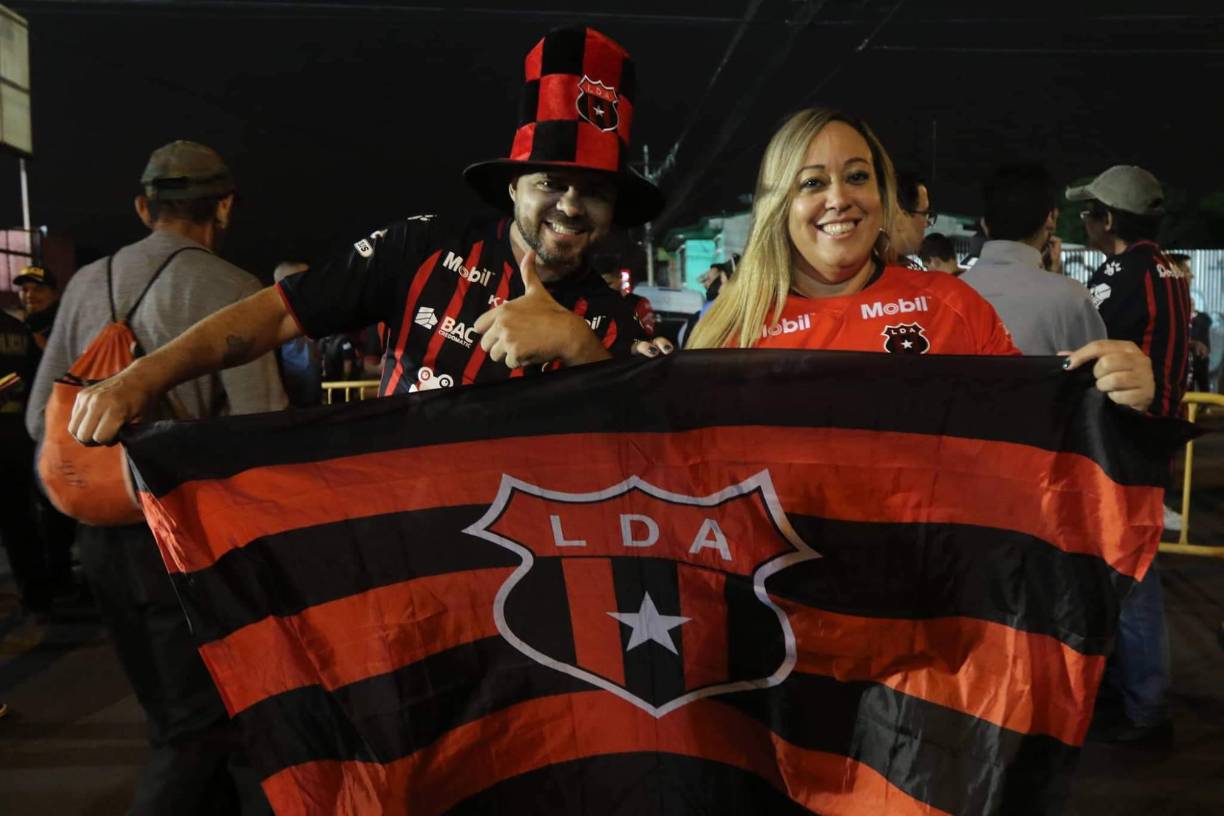 Aficionados del Alajuelense bien identificados con los colores de su amado equipo.