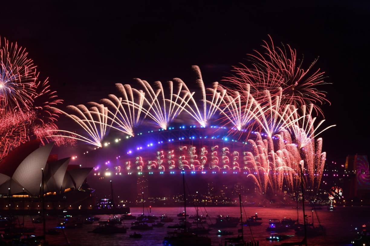  Los fuegos artificiales de medianoche se ven sobre la Ópera de Sydney y el Sydney Harbour Bridge durante las celebraciones de Nochevieja en Sydney, Australia, el 1 de enero de 2022.