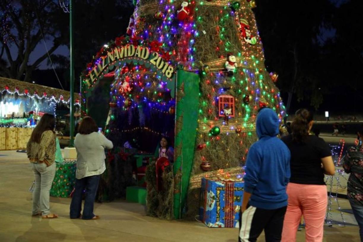 Las personas que asisten a este lugar se toman fotografías en este precioso árbol totalmente decorado.