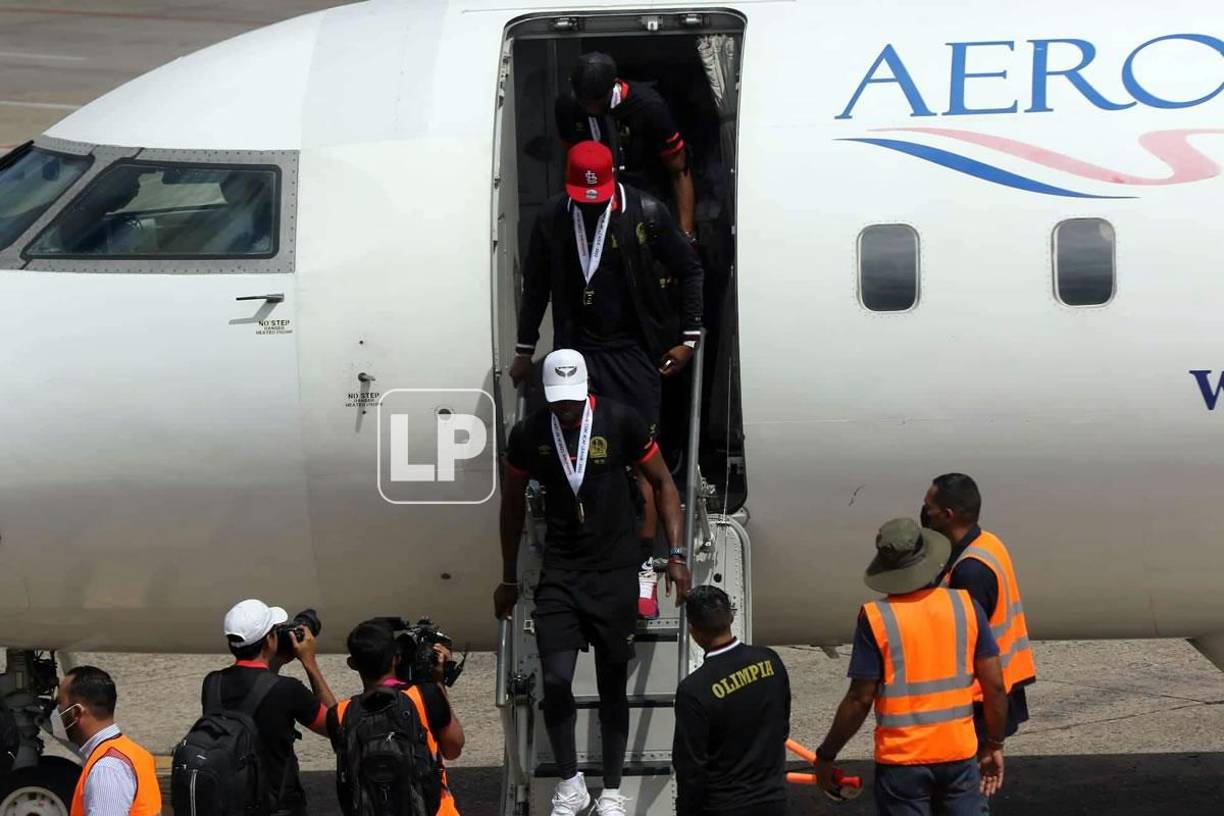 Los jugadores del Olimpia salieron del avión con las medallas de campeones colgadas de sus cuellos.