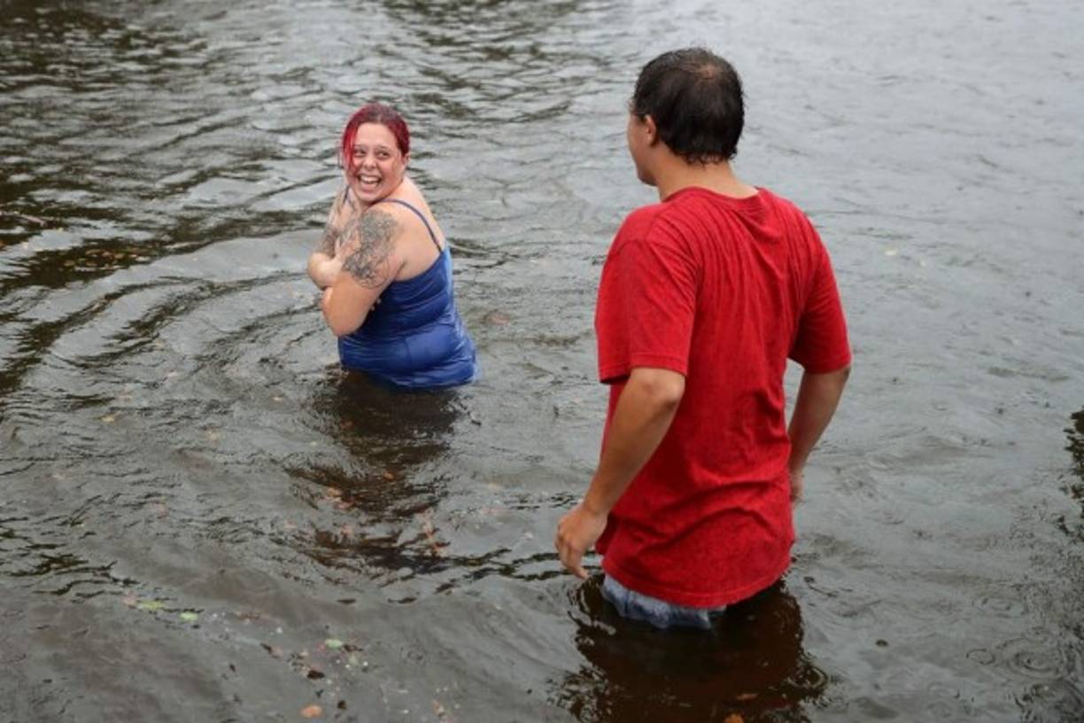 Shianne Coleman (L) y Austin Gremmel caminan por calles inundadas cuando el río Neuse comienza a inundar sus orillas durante el huracán Florence el 13 de septiembre de 2018 en New Bern, Carolina del Norte. AFP