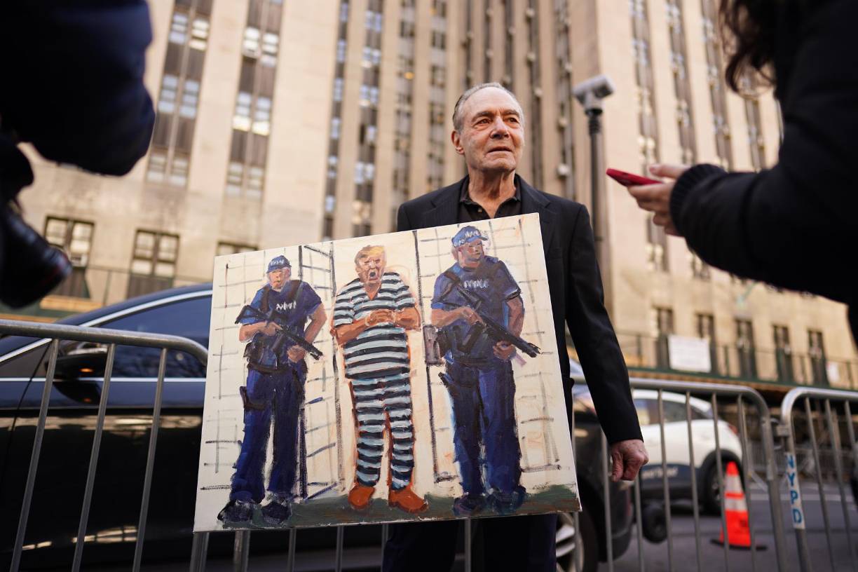  Un miembro del público sostiene un cartel de Trump frente a la Corte Penal de Nueva York.