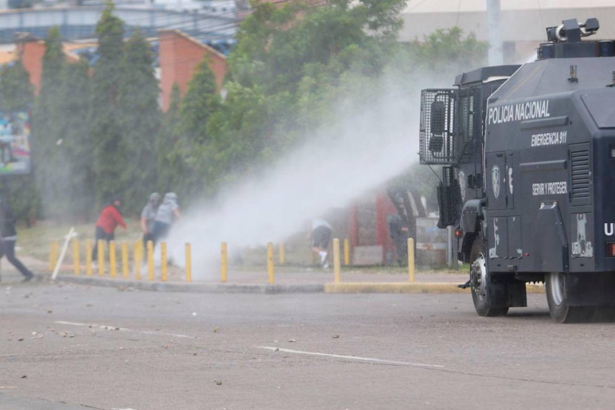 Tras los duros ataques de los estudiantes que lanzaban piedras, una tanqueta policial los dispersó con agua picante. 