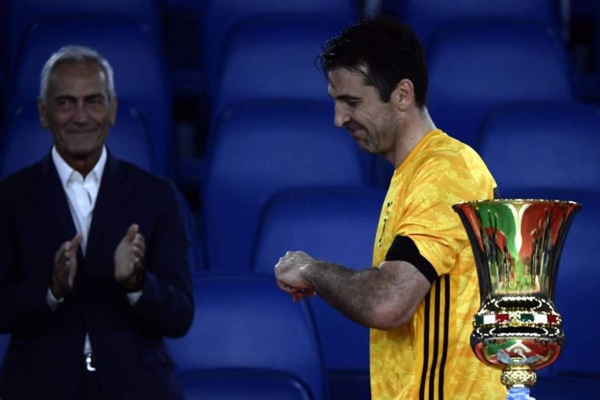 Buffon pasando al lado del trofeo que perdió la Juventus.