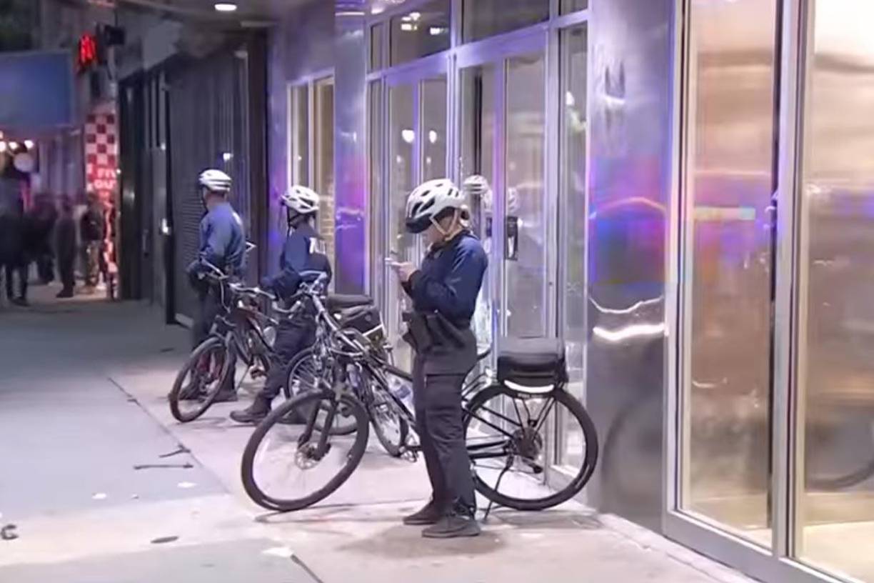 Una tienda de Apple es resguardada por policías después de haber sido saqueada.