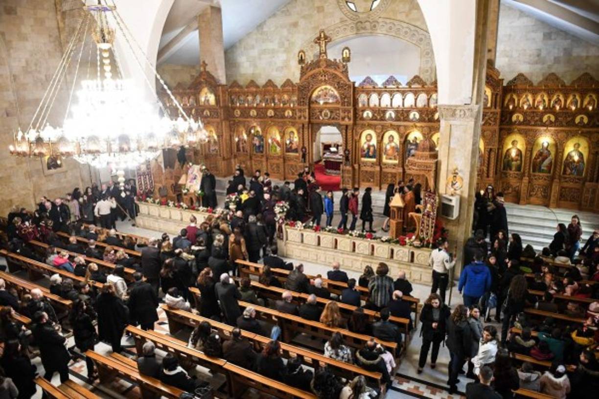 Los fieles reciben la comunión durante la misa de la mañana de Navidad en la Iglesia Ortodoxa Griega Profeta Elías en la ciudad de Alepo, Siria.