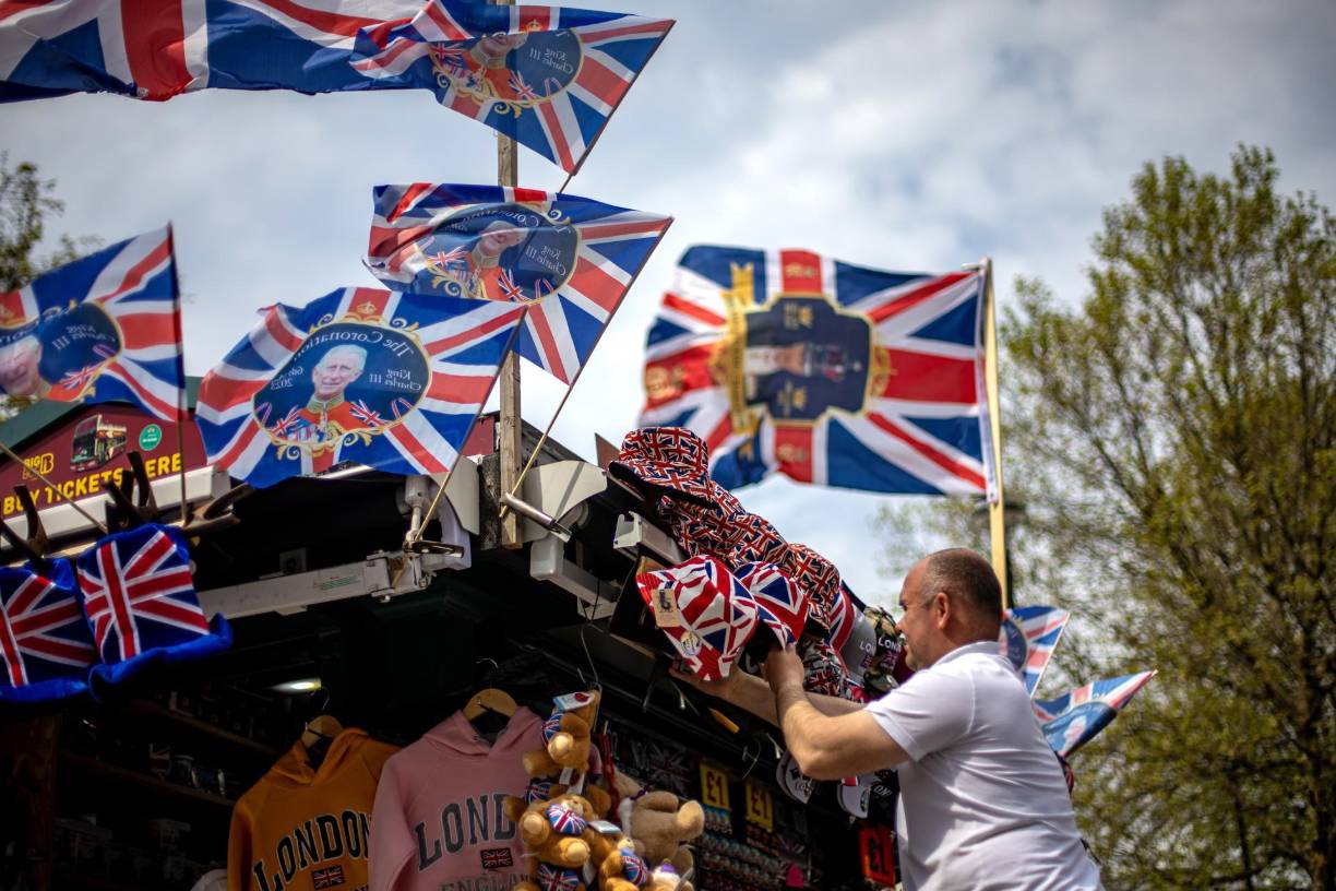 Un vendedor ambulante ajustando suvenires en Londres, donde será la ruta de procesión de coronación.