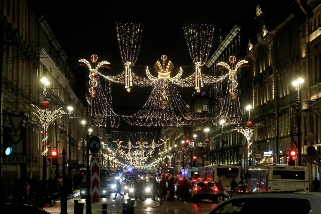 Ciudadanos rusos cruzan la avenida Nevsky Prospect, decorada estacionalmente antes de las celebraciones de año Nuevo y Navidad, en San Petersburgo.