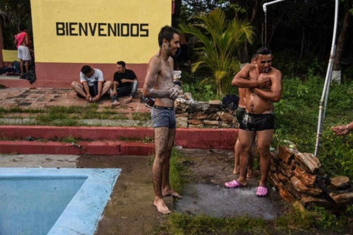 Migrantes se duchan en un centro turístico abandonado en San Agustín Acasaguastlan, El Progreso, Guatemala.