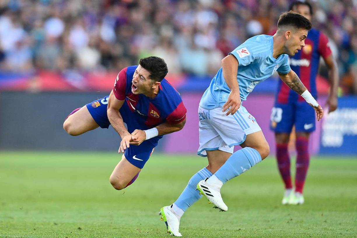 Robert Lewandowski cayendo al suelo tras una falta de Fran Beltrán.