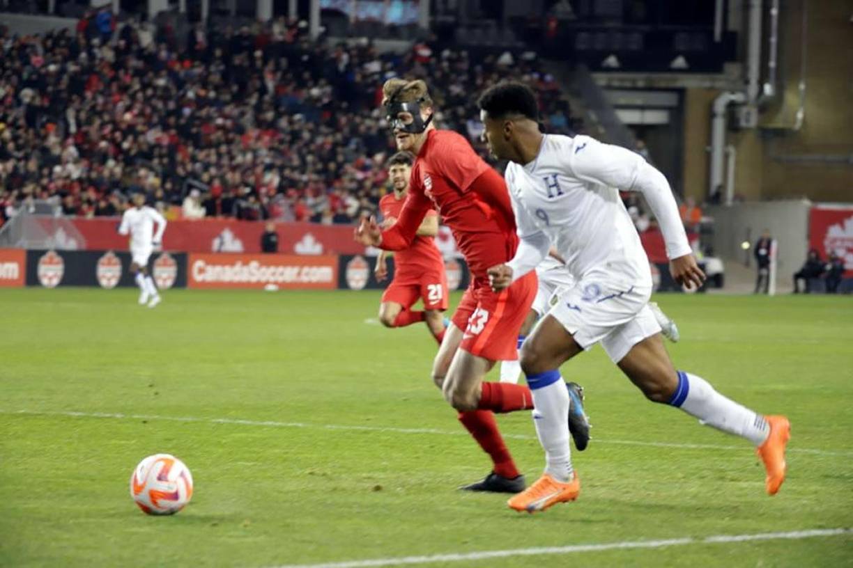 ‘Choco’ Lozano es seguido por el enmascarado defensor canadiense Scott Kennedy.