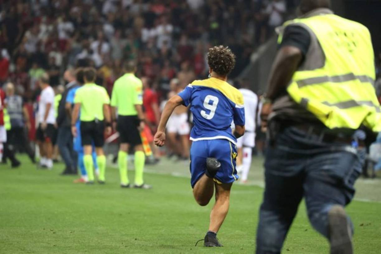 Un aficionado corriendo para evitar ser detenido por la seguridad del estadio del Niza.