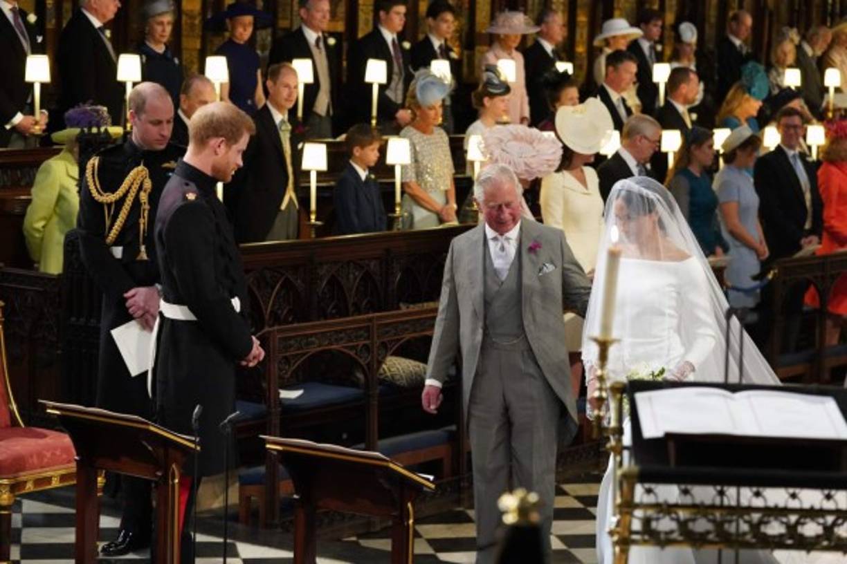 El príncipe Harry, duque de Sussex (2 ° L), mira a su novia, Meghan Markle, cuando llega acompañada por el príncipe Carlos de Gran Bretaña, Príncipe de Gales en la Capilla de San Jorge durante la ceremonia de boda del príncipe Harry, Duque de Sussex y Gran Bretaña La actriz estadounidense Meghan Markle en la Capilla de San Jorge, en el Castillo de Windsor, en Windsor, el 19 de mayo de 2018.<br/>Jonathan Brady / PISCINA / AFP