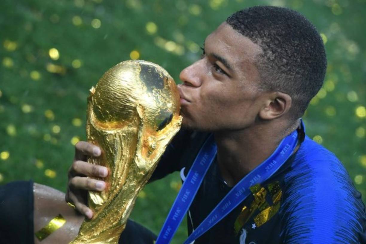 Kylian Mbappé besando el trofeo de la Copa del Mundo.