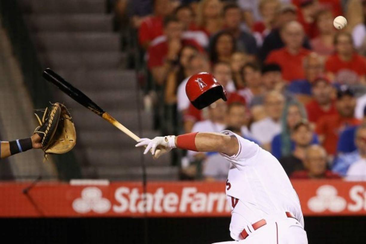 BÉISBOL. ¡Cuidado! Albert Pujols, de los Angelinos, reacciona al ser golpeado en la cabeza por un lanzamiento de Tony Barnette, de los Rangers de Texas. Foto: AFP/Sean M. Haffey