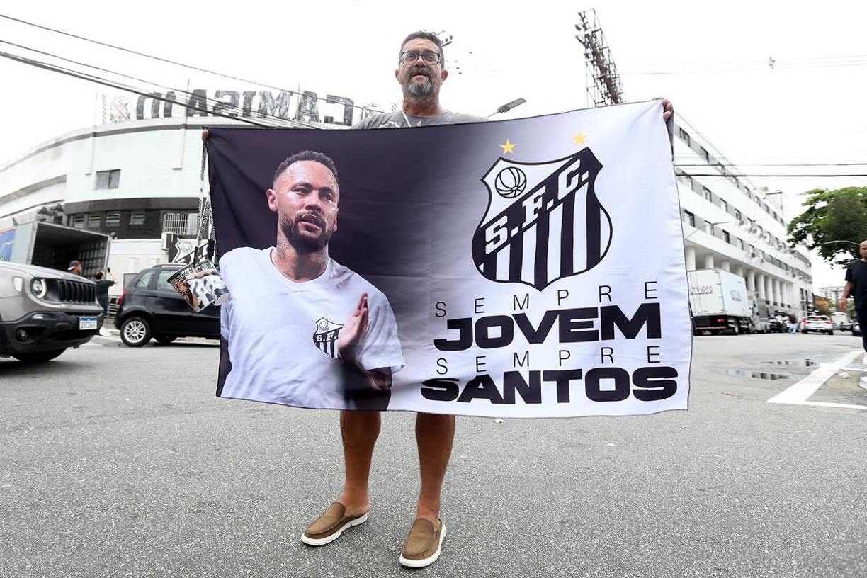 Un aficionado del club Santos sostiene un cartel con la imagen delantero brasileño Neymar este viernes, cerca al estadio Vila Belmiro.