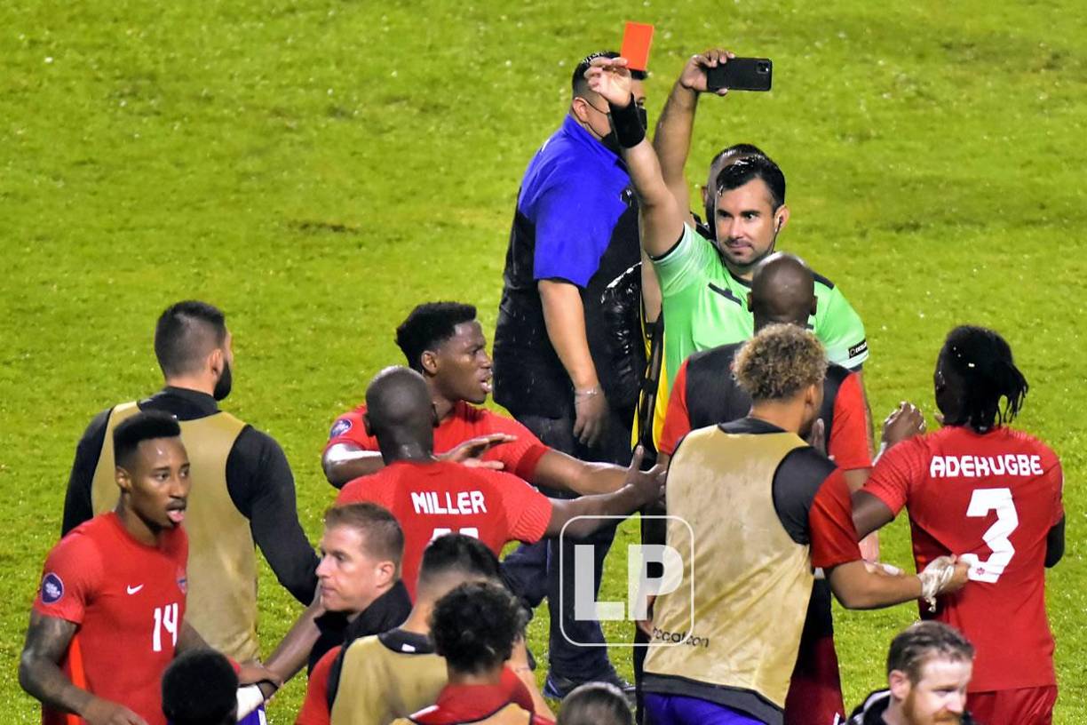 El árbitro guatemalteco Mario Escobar sanciona con tarjeta roja a Alistair Johnston tras el final del partido.