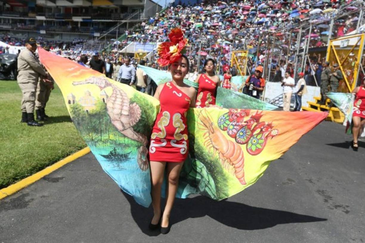 Radiantes trajes típicos y bellas chicas fascinan al público en los desfiles.