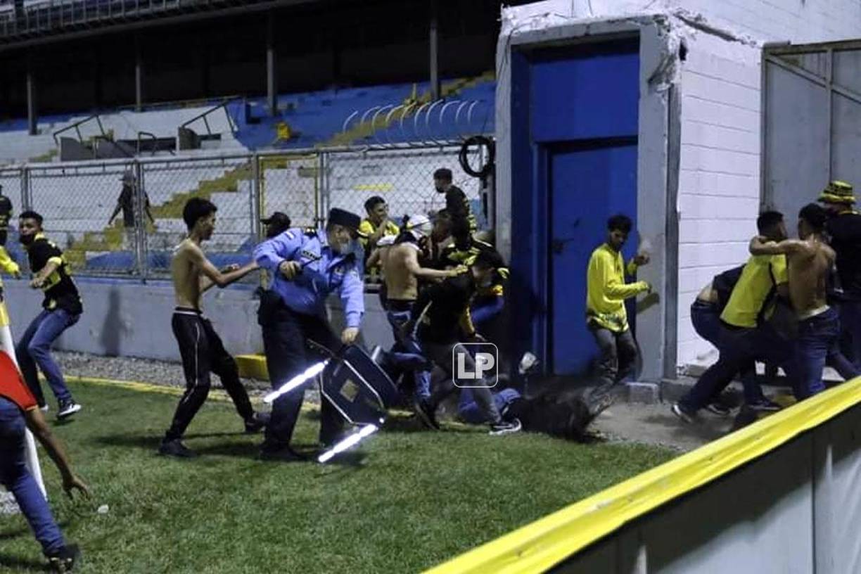 Los aficionados lanzaron al suelo a la mujer vestida con un jean y una camisa negra.