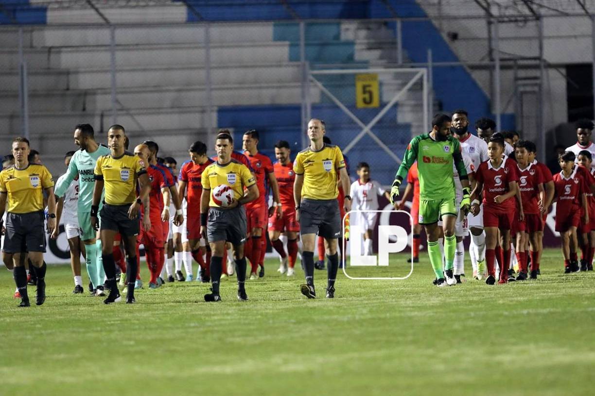 La salida de los equipos titulares de Olimpia y Municipal a la cancha, encabezados por la cuarteta arbitral.